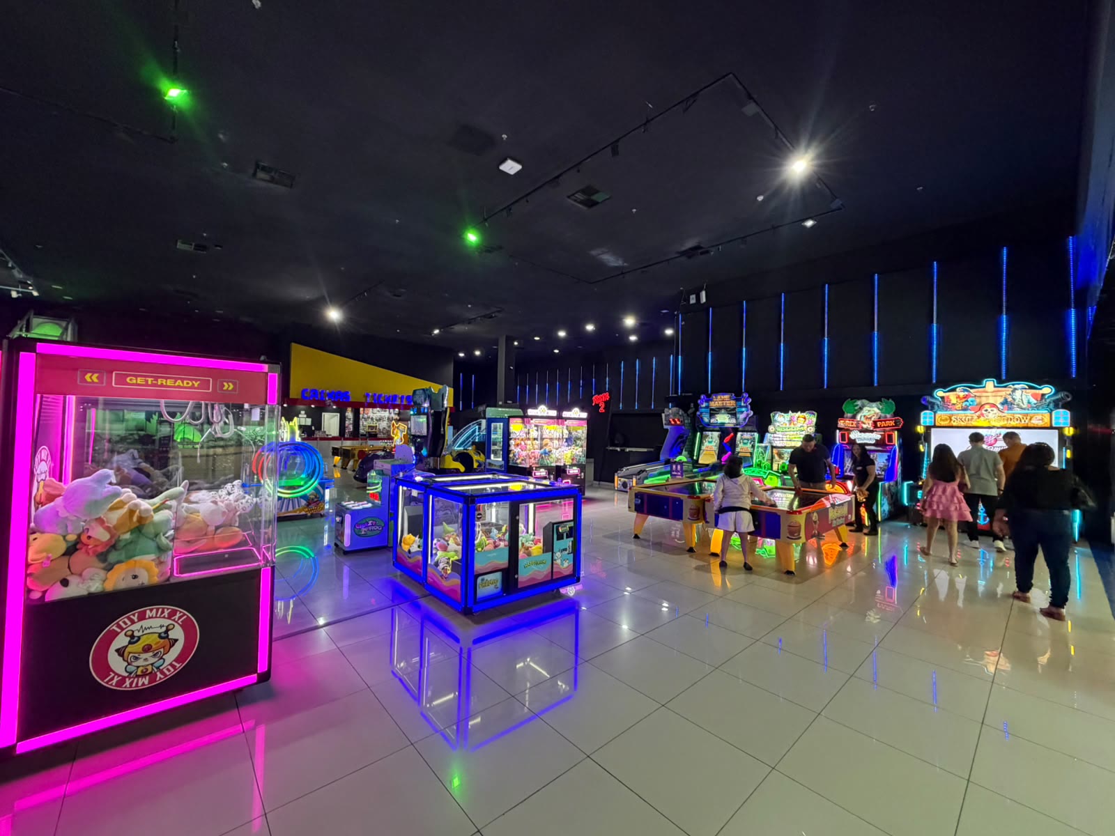Interior de um parque Planet Park com fliperamas e clientes